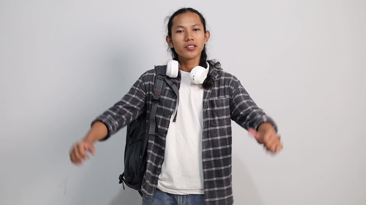 Young Asian college student showing thumbs down and expressing dislike