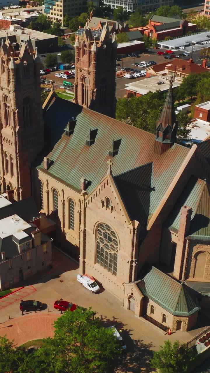 Magnificent building of Madeleine Cathedral among the urban architecture. Beautiful historic church of Salt Lake City from aerial perspective. Vertical video