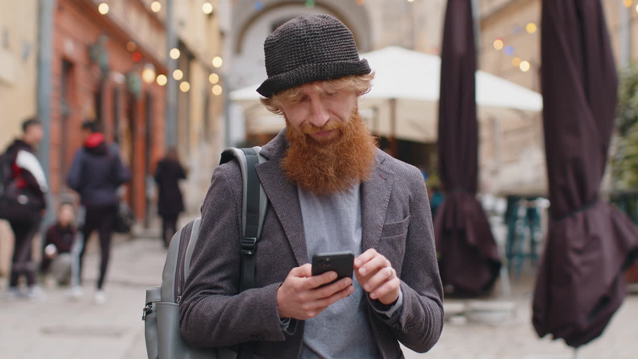 Young man using smartphone typing text messages looking for a way on map in mobile navigator app