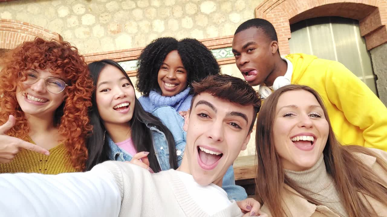 Cool millennials taking a selfie with friends outdoors