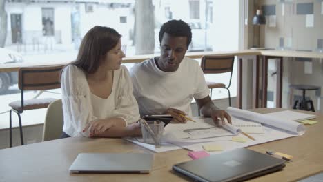 couple de jeunes designers sérieux assis à table