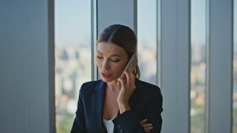 closeup office woman calling cell at panoramic window. corporate manager talking