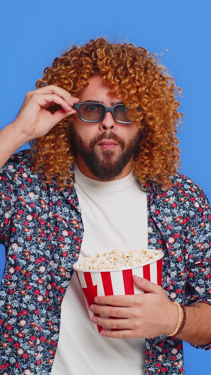 Excited man in 3d glasses eating popcorn watching interesting tv serial sport game cinema film