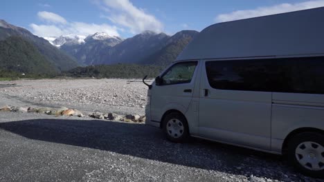 SLOWMO---Motorhome-with-in-background-snowcapped-mountains-in-Franz-Josef-Glacier,-New-Zealand