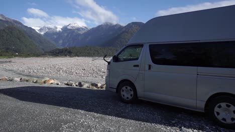 slowmo - autocaravana con montañas nevadas de fondo en el glaciar franz josef, nueva zelanda