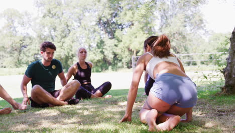 instructora que dirige una clase de yoga al aire libre