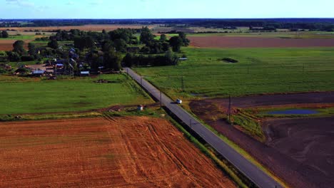 Asphalt-Road-In-The-Midst-Of-Rural-Field-Near-The-Town-In-Lithuania