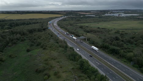 Rising-Establishing-Aerial-Drone-Shot-of-M1-Motorway-at-Dawn-on-Cloudy-Day-with-Vehicle-Lights