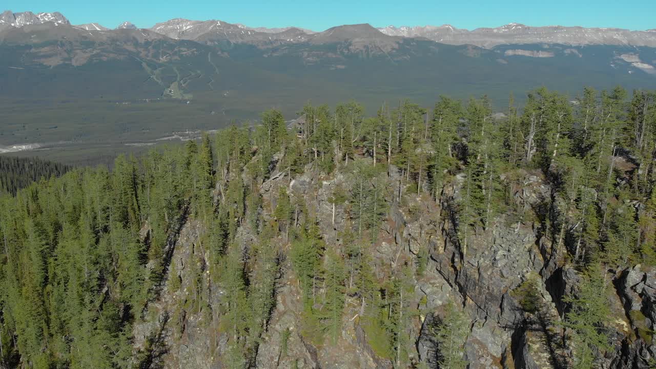 vuelo aéreo con drones sobre un bosque de pinos en la montaña durante el día, banff, canadá