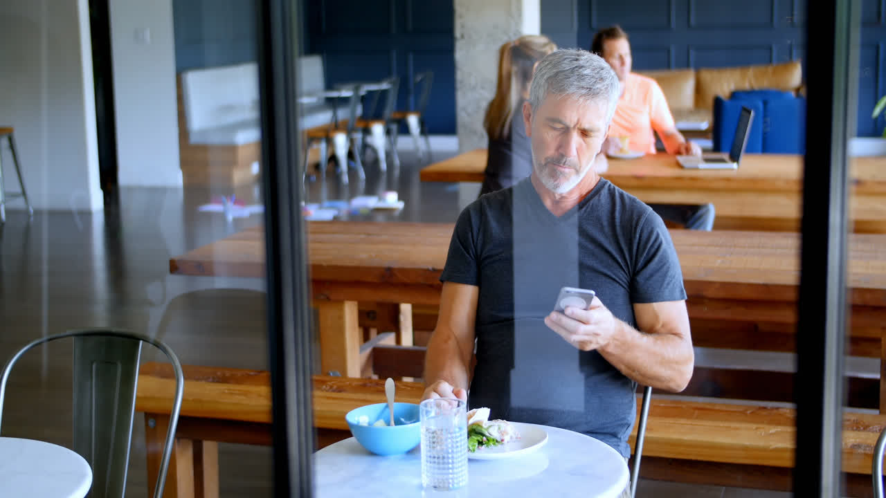 ejecutivo usando teléfono móvil mientras come 4k