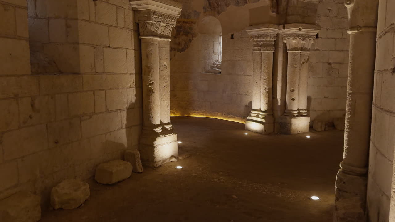 Ancient stone crypt with Romanesque columns and medieval frescoes, dimly lit interior