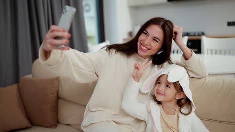 madre e hija tomando una selfie en casa