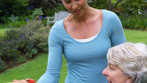 female coach assisting senior woman in performing exercise