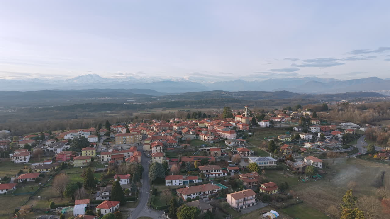 Immagine aerea di Sumirago, un paese in provincia di Varese, circondato da dolci colline e tetti, con una luce soffusa e mistica