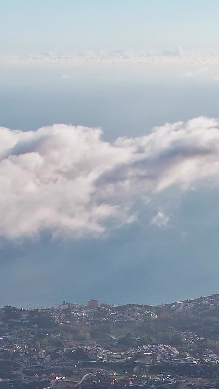 View of Malaga from high above with clouds and the sea