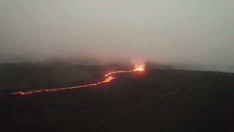 mid angle drone shot of the litli hrutur volcano in iceland with fog and smoke