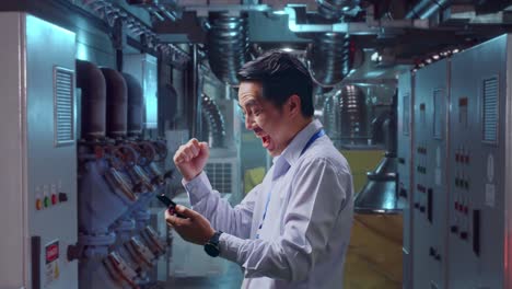 excited factory worker checking smartphone