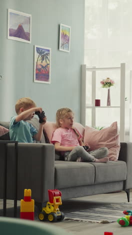 siblings play captivating video game with consoles in living room with scattered toys. little boy and girl compete showing gaming skills at home