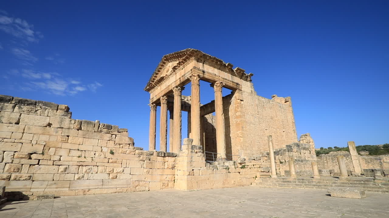 antiguas ruinas romanas en dougga bajo un cielo azul claro, toma amplia