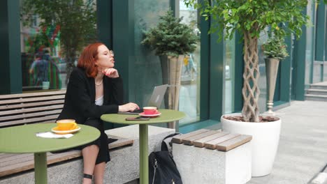 woman working on laptop in outdoor cafe