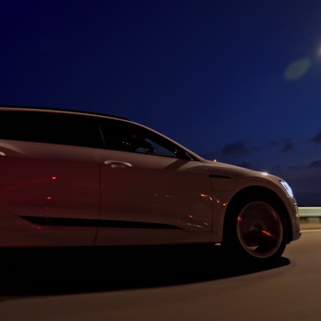luxury car moving on the road at night. evening background on the highway and beautiful audi driving with bright headlights on.
