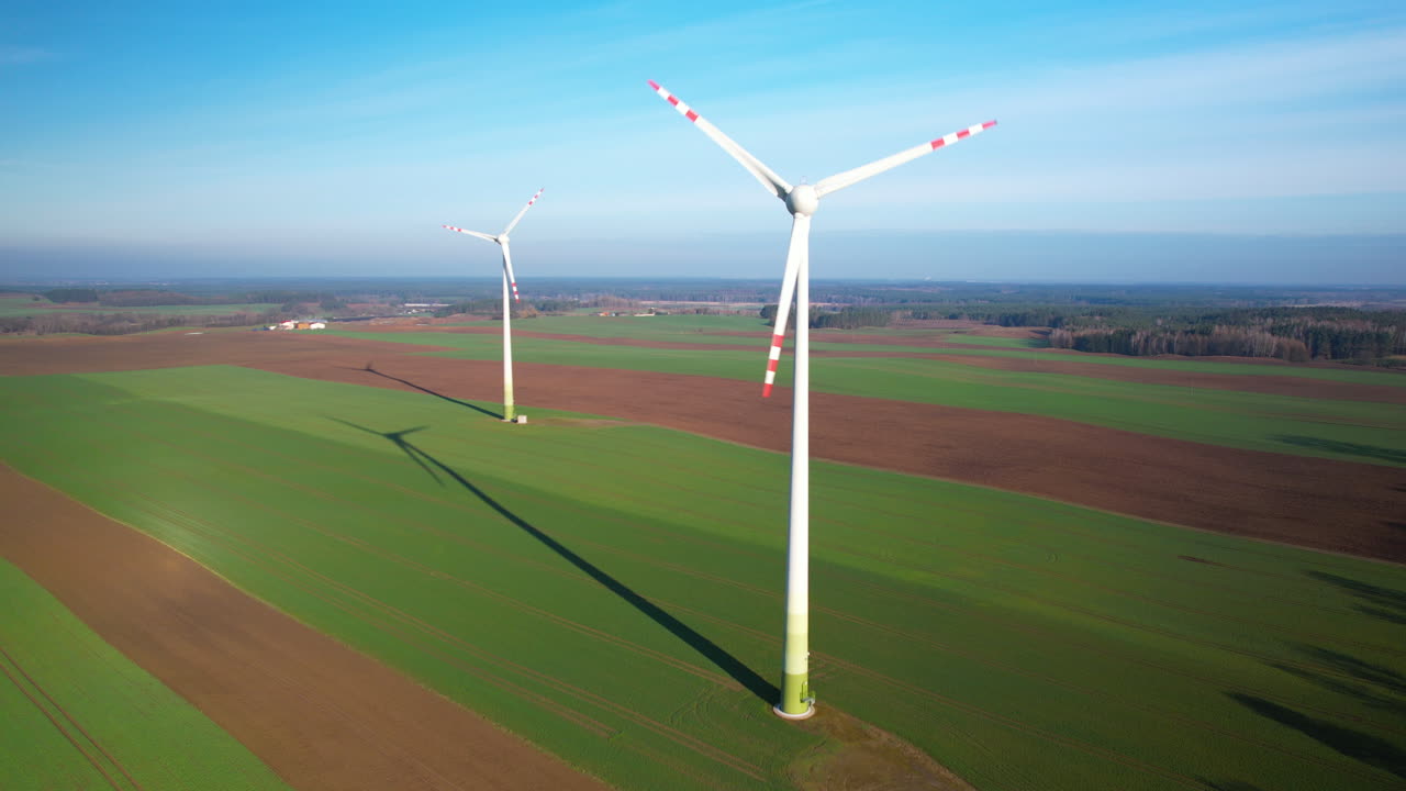 Rotating wind turbines in Polish farmland on Spring Sunny Day