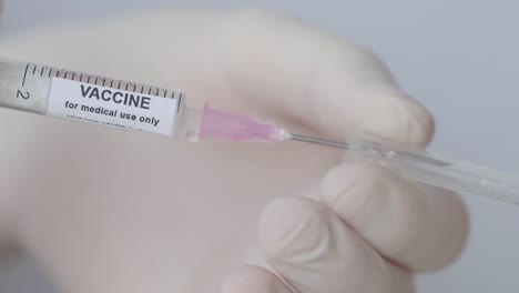 hand removing cap of syringe needle - vaccine for medical use only - close up, slow motion