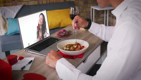 Pareja-Caucásica-Haciendo-Videollamada-De-Fecha-De-San-Valentín-Hombre-Comiendo-Comida-Mujer-Sonriendo-En-La-Pantalla-Del-Portátil