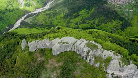 aerial tilt up shot of small plateau belintash in rhodope mountains and green landscape in bulgaria