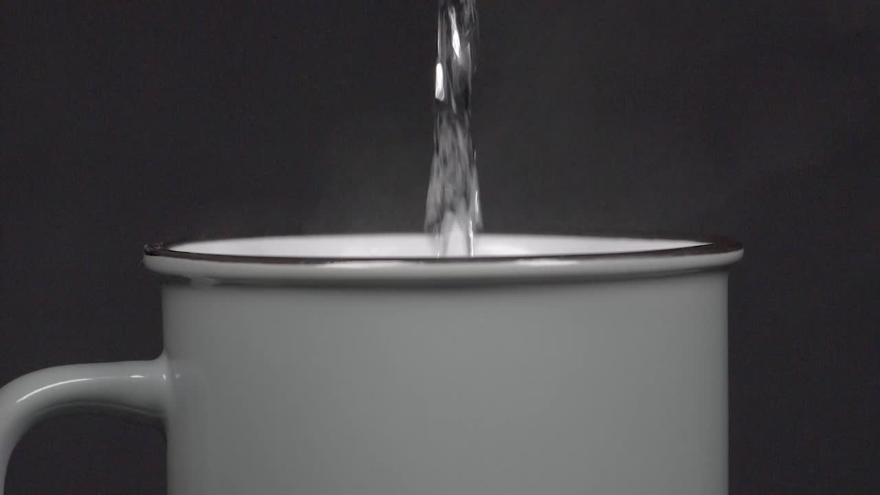 Filling cup with hot water with vapour, slow motion 4K