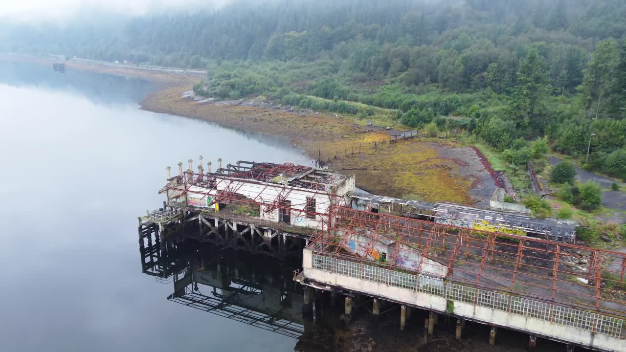 edificio abandonado de la gama de torpedos en loch long cerca de arrochar, tierras altas escocesas, costa oeste de escocia - filmación aérea de drones 4k hd, enfoque