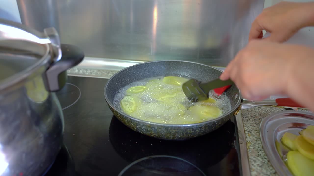 Deep Frying Sliced Potatoes In A Pan With Cooking Oil - close up
