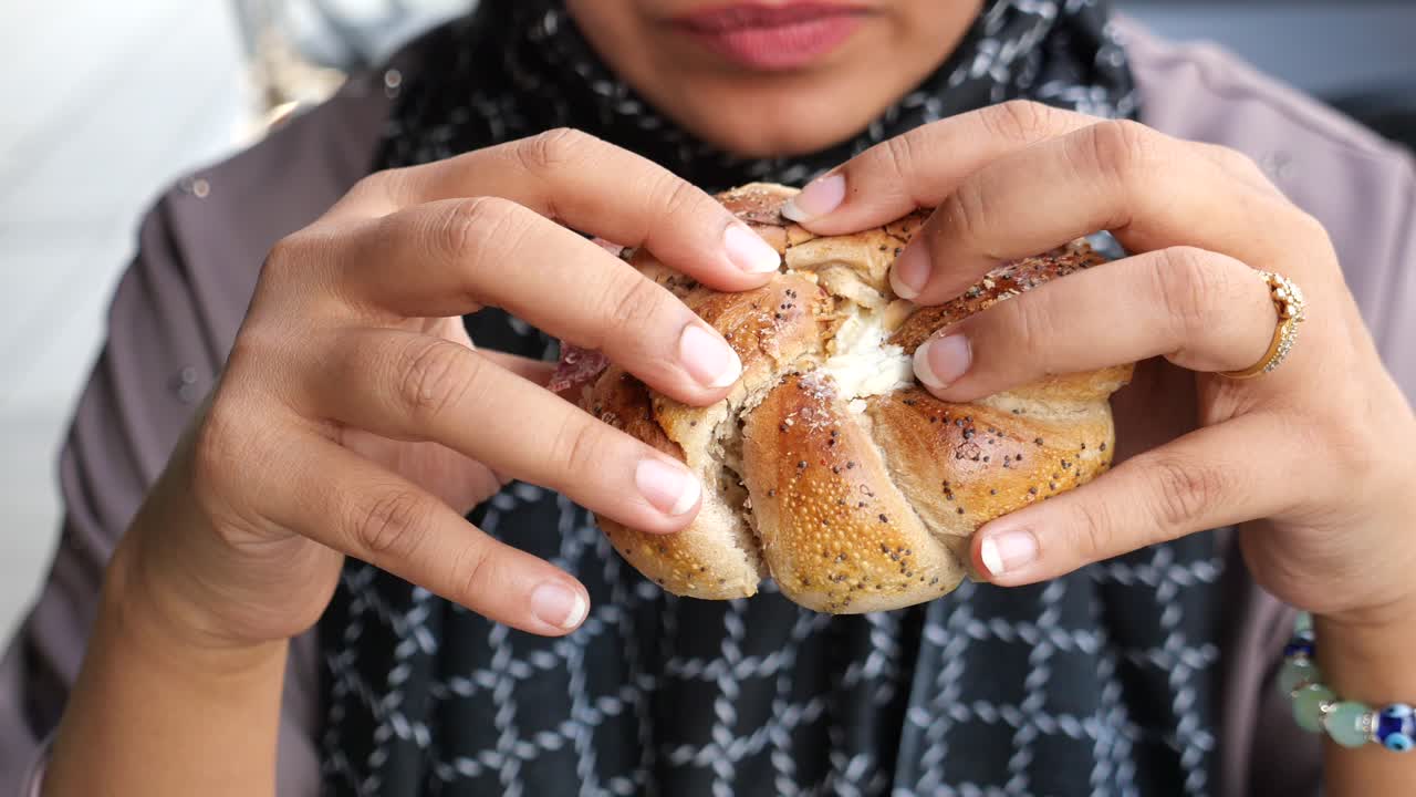 una mujer comiendo un bagel.
