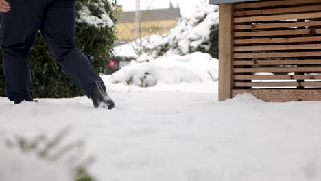 slow motion of person walking through snow covered yard after strong snowstorm during daylight