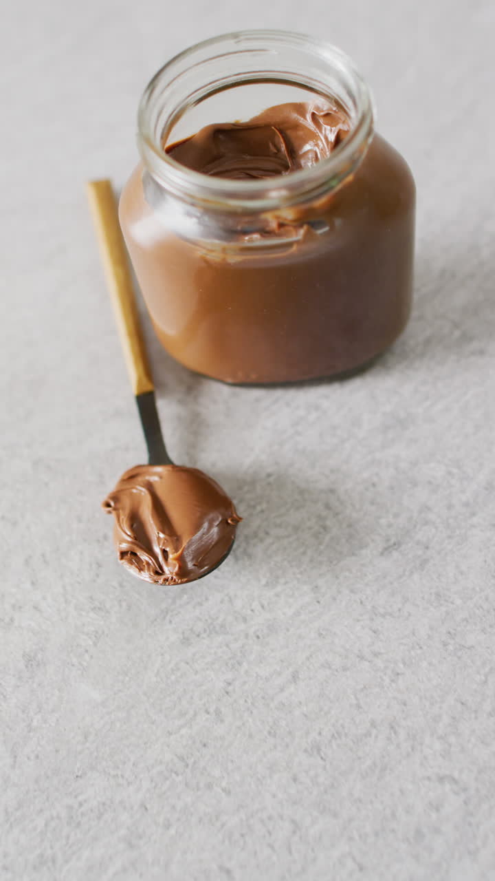 Video verticale di primo piano di crema al cioccolato su sfondo grigio