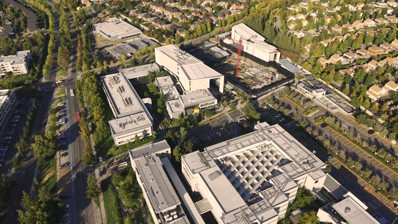 Højvinkel luftfoto af moderne Universidad del Desarrollo universitets campusbygninger, omkringliggende beboelsesgader og en byggekran. Chile, 4K.