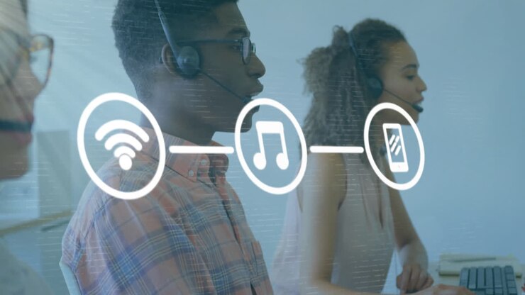 Animation of media icons over diverse business people using phone headsets in office