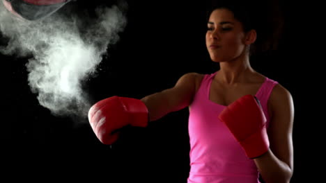 fit woman in pink punching speed bag