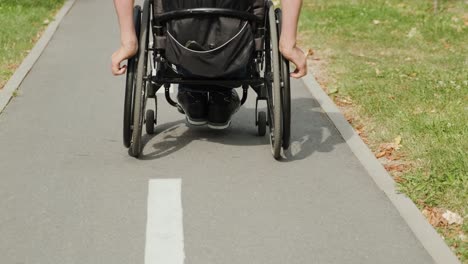 man with disabilities in wheelchair walk at the park alley