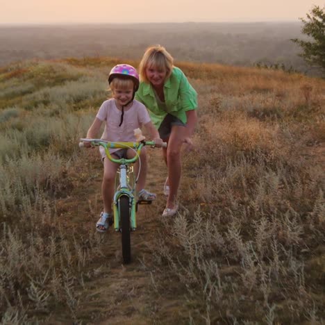 mother teaches her daughter to ride a bicycle