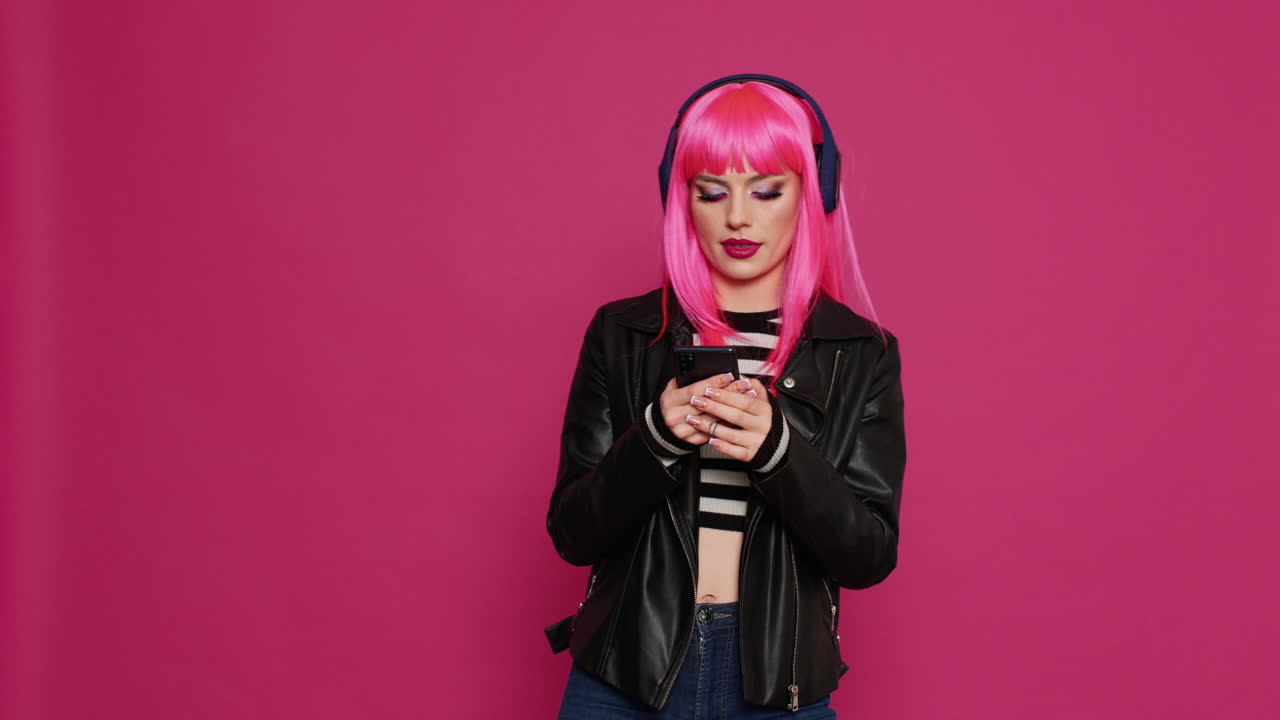 Trendy positive woman listening to music on headphones