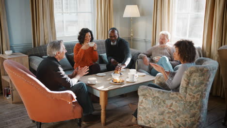 Grupo-De-Amigos-De-Mediana-Edad-Reunidos-Alrededor-De-Una-Mesa-En-La-Cafetería.