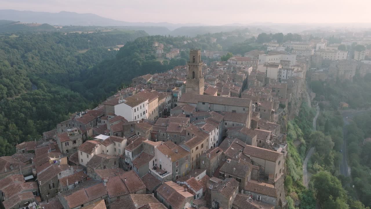 Aerial Drone view of the hilltop Medieval town of Pitigliano, Tuscany and the Valdorcia in morning light, flying over old buildings and rooftops, in 4K