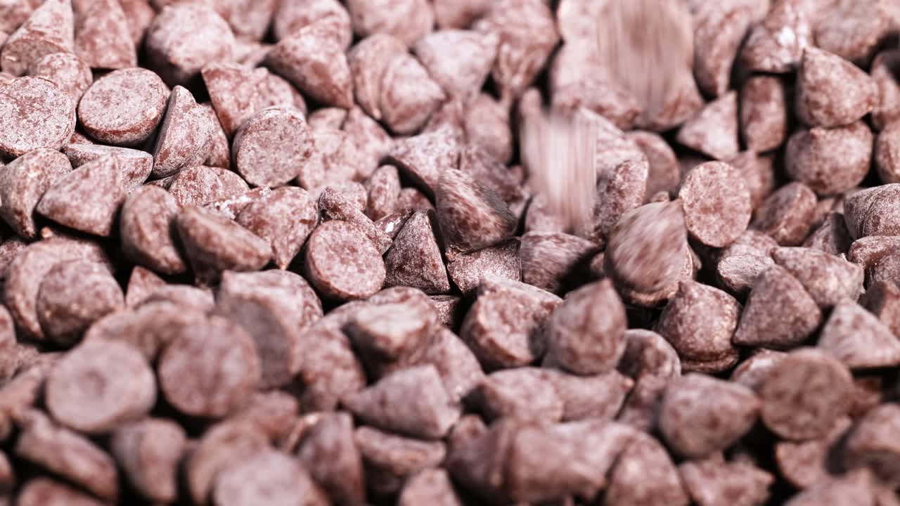 Spoon scooping chocolate chips from a pile