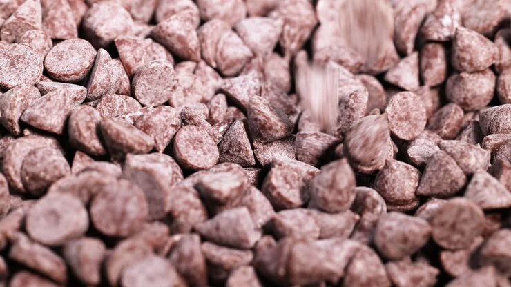 Spoon scooping chocolate chips from a pile