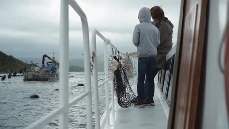 kids standing on boat deck and looking at new zealand greenshel mussel farm