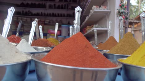 close up overview across lots of vibrant colourful herb - spice powders in outdoor store market scene