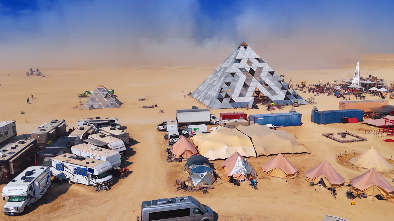 Nevada, USA, 25 August 2025: Drone aerial shot of recreational vehicles and tents near the mirrored pyramid structure at Burning Man