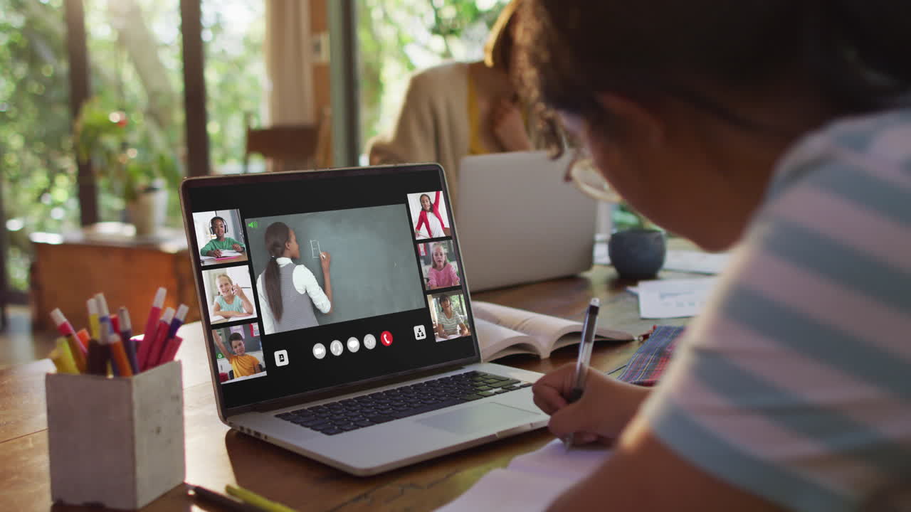 estudiante que usa una computadora portátil para una lección en línea en casa, con un maestro y una clase diversos en la pantalla
