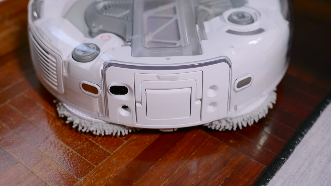 Close-up of a person removing the dustbin and filter from a white robotic vacuum cleaner. Smart home maintenance and cleaning. Ideal for modern technology and home automation concepts